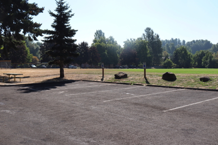 Parking lot with accessible space behind play ground – picnic table on cement